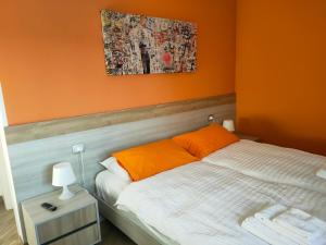 a bedroom with a bed with an orange wall at B&B Rio Rai in Gemona del Friuli