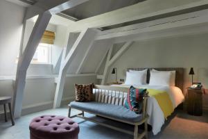- une chambre avec un grand lit et une chaise bleue dans l'établissement Pulitzer Amsterdam, à Amsterdam