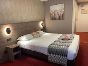 a hotel room with a large bed and a table at Logis Hotel-Restaurant Spa Le Lac in Embrun