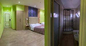 LushnjëにあるPilo Lala Hotelのベッド1台、緑の壁のバスルームが備わります。