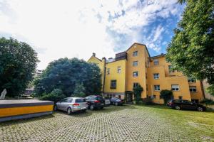grupa samochodów zaparkowanych na parkingu przed budynkiem w obiekcie Hotel Lehenerhof w mieście Salzburg