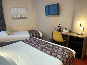 um quarto de hotel com duas camas e uma secretária em Logis Hotel-Restaurant Spa Le Lac em Embrun