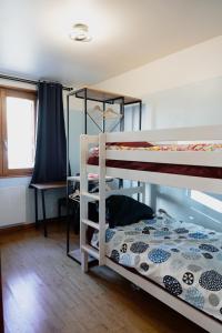 聖克洛德的住宿－KASA JURA - Au coeur des monts，一间卧室配有两张双层床和一张书桌