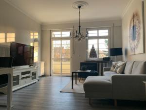 Il comprend un salon doté d'un canapé et d'une télévision à écran plat. dans l'établissement Apartmenthaus Villa Lindenbühl, à Mühlhausen