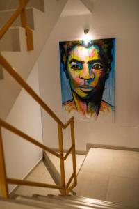 a painting of a woman on a wall next to a staircase at Amwilla Guesthouse Apartamento Elsa in Mindelo