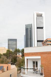 budynek z balkonem przed wysokimi budynkami w obiekcie Apartamentos Las Torres w Madrycie