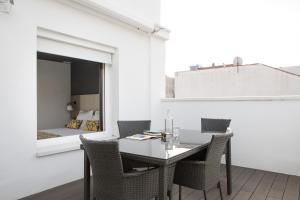 a dining room with a table and chairs and a bed at Apartamentos Las Torres in Madrid
