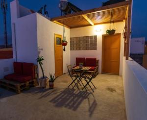 a patio with a table and chairs on a house at Amwilla Guesthouse Apartamento Elsa in Mindelo