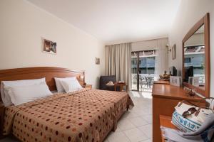 a hotel room with a bed and a desk and a bedroom at Porfi Beach Hotel in Nikiti