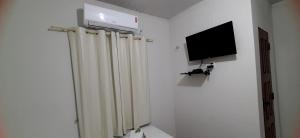 um quarto com um radiador e uma televisão na parede em Pousada Brilho dos Lençóis em Barreirinhas