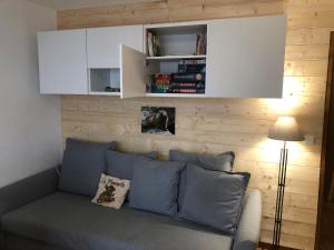 a living room with a gray couch and white cabinets at Le chalet de "Lamarmotte" T3 rénové avec terrasse sud en rez de jardin in Super Besse