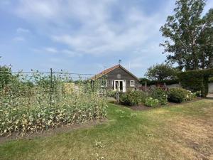 ein Garten mit einem Haus im Hintergrund in der Unterkunft Stable Cottage in Sandwich