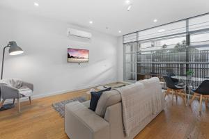 a living room with a couch and a table at Newly Refurnished Beachside 1-Bedroom Apartment in Melbourne