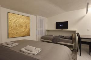 a bedroom with a bed and a tv on the wall at TALEDA Apartments - Modern Apartments & Self Checkin in the Old Town in Lugano