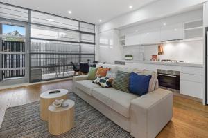 a living room with a couch and a table at Newly Refurnished Beachside 1-Bedroom Apartment in Melbourne
