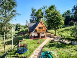 a small house on a hill with boats in the yard at Domek u Justyny in Kościelisko