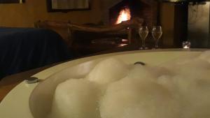 a bath tub filled with foam next to two wine glasses at Del Viejo Camino in El Bolsón
