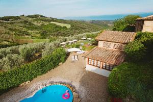 - une vue aérienne sur une maison et une piscine dans l'établissement Relais Villa Olmo, à Impruneta