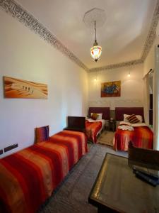 1 dormitorio con 2 camas y lámpara de araña en Riad Alma Mouassine en Marrakech