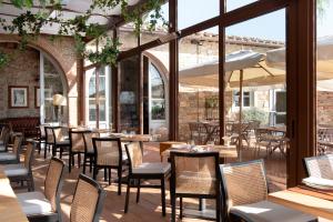 a restaurant with tables and chairs and large windows at Relais Villa Olmo in Impruneta