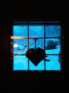 a person standing in front of a window looking at the water at Casa All'Alpe in Anzino