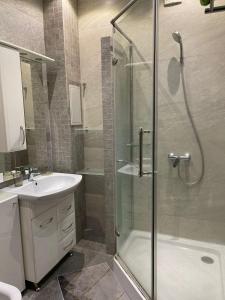 ein Badezimmer mit Dusche und Waschbecken in der Unterkunft 1 комнатная квартира в элитном ЖК Альтаир со всеми удобствами in Aqtöbe