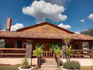 una casa con un techo con plantas delante en Cabaña el piñon en Ezequiel Montes, en Ezequiel Montes