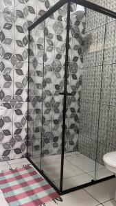 a bathroom with a toilet and a glass wall at Edicula Fundos in Jordãozinho