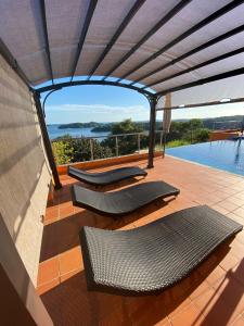 d'une terrasse avec des chaises et une vue sur l'eau. dans l'établissement Boca Chica Bay Eco Lodge, à Boca Chica