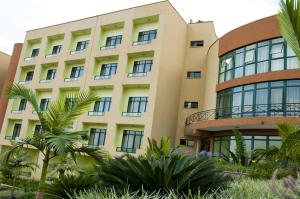 un edificio con palmeras delante en Gorillas Golf Hotel, en Kigali