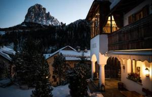 a building with a mountain in the background at Charme Hotel Uridl in Santa Cristina Gherdëina