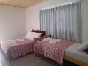 two beds sitting next to each other in a room at Edicula Fundos in Jordãozinho