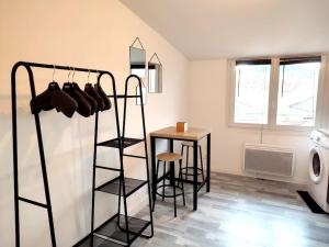 a room with a table and a laundry room with a drying rack at Studio rue Leopold bourg in Épinal