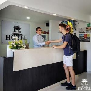 CiénagaHotel Don Jose的站在一家小餐馆柜台上的男人