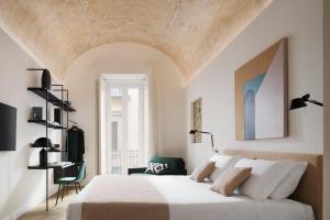 une chambre avec un grand lit blanc et une chaise dans l'établissement Mirabilis Relais, à Naples