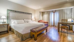 um quarto com uma cama grande e uma secretária e uma cama sidx sidx sidx em Roc Blanc Hotel & Spa em Andorra-a-Velha