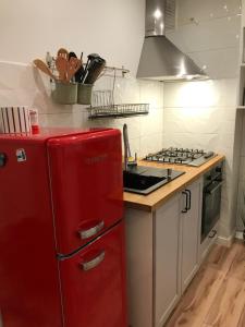 - un réfrigérateur rouge dans la cuisine équipée d'une cuisinière dans l'établissement Apartament w centrum miasta, à Suwałki