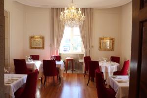a dining room with tables and chairs and a chandelier at Solar do Requeijo by Luna Hotels & Resorts in Arcos de Valdevez