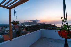 a balcony with a view of the ocean and a mountain at Amwilla Guesthouse Apartamento Fátima in Mindelo