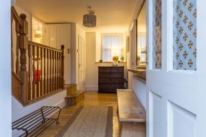 a hallway with a staircase with a bench and a window at The White House at The Tinners Arms in St Ives