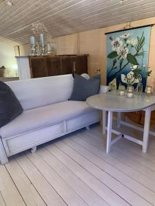 a living room with a white couch and a table at Landhaus „Blattgold“ in Lohme