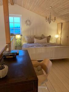 a bedroom with a bed with a table and a chair at Landhaus „Blattgold“ in Lohme