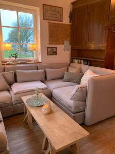 a living room with a couch and a table at Landhaus „Blattgold“ in Lohme