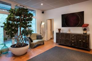 a living room with a tree and a dresser at Gîte Bellene Villa de vos Rêves in Beaune