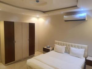 a bedroom with a large white bed and a closet at برج الياسمين 2 in Riyadh