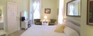 ein Schlafzimmer mit einem weißen Bett und ein Wohnzimmer in der Unterkunft Franklin Terrace Bed and Breakfast in Franklin