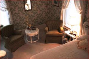 ein Wohnzimmer mit einer Couch und Stühlen und einem Tisch in der Unterkunft Franklin Terrace Bed and Breakfast in Franklin