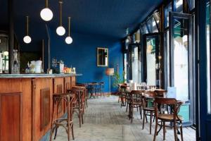 a restaurant with blue walls and wooden tables and chairs at Entire Flat in Euston-Kings Cross in London