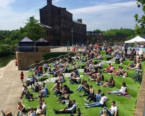 a large group of people sitting on the grass at Entire Flat in Euston-Kings Cross in London
