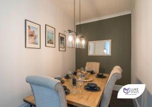uma sala de jantar com uma mesa de madeira e cadeiras em Luke Stays - Brighton Road em Gateshead